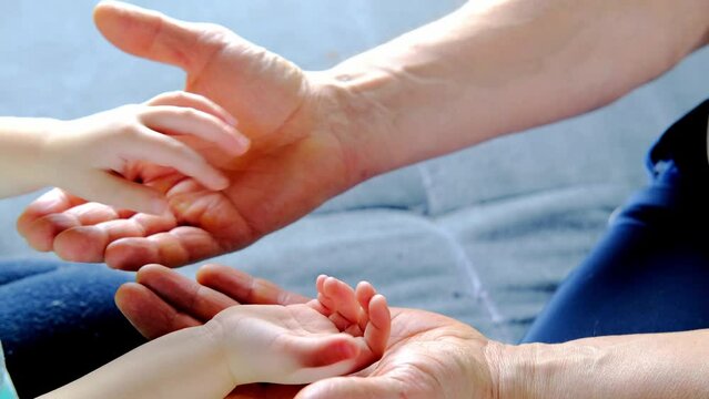 adult male hands holding kid hands, Family Help Care Concept, small hands in fathers hand, touching moment, touch of child and old man, grandfather, parents and child, adopted children, adoption