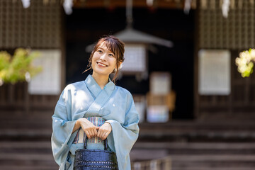 神社の境内を歩く浴衣姿の日本人女性