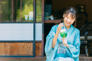 縁側でクリームソーダを飲む浴衣姿の日本人女性