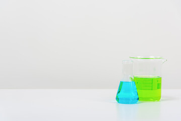 some test tube on the white table  with beakers, flasks, and test tubes filled with colorful liquids