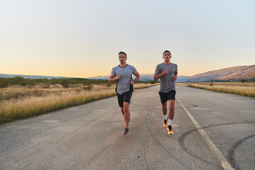 Fototapeta premium Group of handsome men running together in the early morning glow of the sunrise, embodying the essence of fitness, vitality, and the invigorating joy of embracing nature's tranquility during their