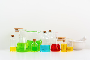 some test tube on the white table with beakers, flasks, and test tubes filled with colorful liquids