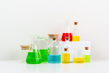 some test tube on the white table with beakers, flasks, and test tubes filled with colorful liquids