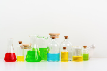 some test tube on the white table with beakers, flasks, and test tubes filled with colorful liquids