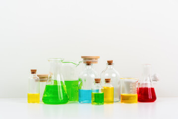 some test tube on the white table with beakers, flasks, and test tubes filled with colorful liquids