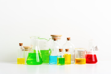 some test tube on the white table with beakers, flasks, and test tubes filled with colorful liquids