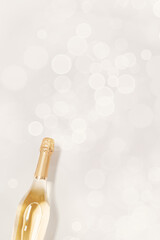Top view sparkling white wine, bottle of champagne with bokeh on beige background, copyspace....