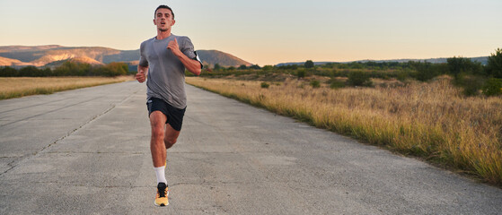A young handsome man running in the early morning hours, driven by his commitment to health and...