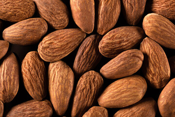 Background of large peeled almonds arranged randomly. Dried products