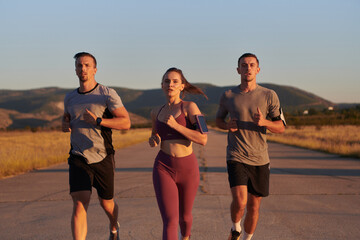 A group of young athletes running together in the early morning light of the sunrise, showcasing their collective energy, determination, and unity 