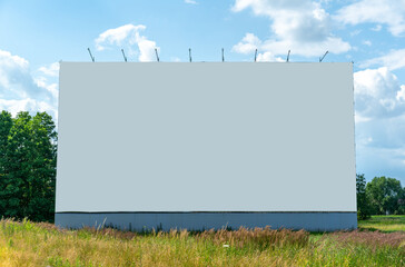 Blank billboard mockup for outdoor advertising standing in green meadow. Empty billboard space for OOH ad.