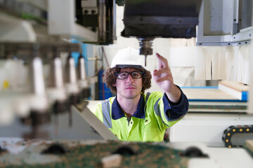 Industrial carpenter man checking the drill of cutting wood on CNC milling machine  in carpentry...
