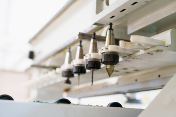 Close-up of cutting wood on CNC router machine angle in carpentry workshop factory. Production line of the wooden working industrial factory.