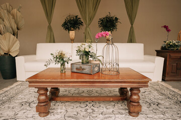 Wedding decoration. Wedding furniture, sofa, shelves, coffee table, plants, leaves.
