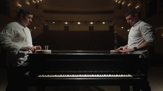 Cooking In Opera, Artistic Shot With Two Chefs Cooks Meals On Grand Piano, Luxury Dinner