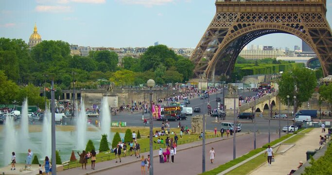 Paris, France, 22 June, 2023: Main French street in Paris with cars and people. City traffic in the city, traffic lights and road signs. People rush to work. Attraction in Paris is the Eiffel Tower