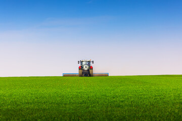 Tractor with a roller tillage on spring field. Soil rolling supports germination and is the basis...
