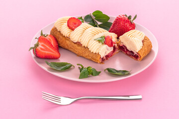 French eclair grazed with chocolate and fruity strawberry cream or sweet Italian profiteroles and...