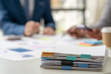 Businessman working in financial accounting with piles of documents on the desk at home work from...