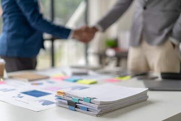 Two business people shake hands after a business deal is reached In the office area