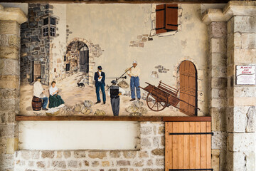 Ancienne fresque murale dans un passage couvert illustrant le commerce des cocons de vers à soie. Thueyts en Ardèche