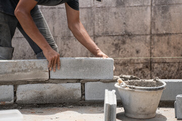 Builders skillfully lay blocks, crafting sturdy walls for a remarkable house. Creating a strong...