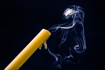 Smoke from an extinguished candle on a dark background. The concept of spirituality and the end of...