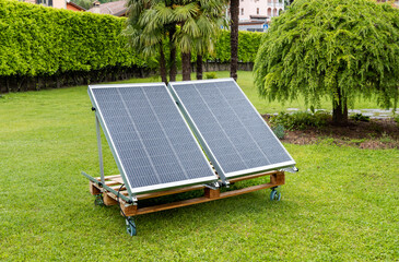 Photovoltaic panels wet from the rain on the wooden pallet in the home garden. Green energy concept.