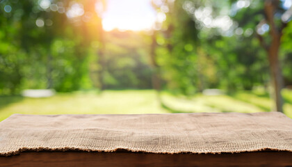 table wood for coffee product, Empty wooden table and sack tablecloth over blur park, garden outdoor with bokeh light background