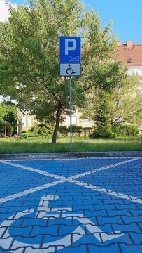 Free Parking space for PWD, indicated by road markings and information sign. Accessible Parking. Road sign Parking only for disabled drivers. Adapted spaces for disabled person. Inclusion.