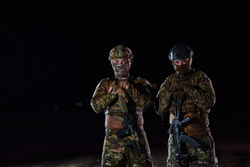 Two professional soldiers marching through the dark of night on a dangerous mission, epitomizing their unwavering bravery, unwavering teamwork, and the high-stakes intensity of their specialized