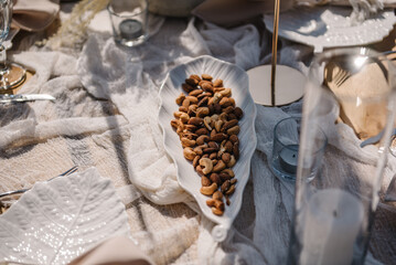 Picnic with food, nuts, wooden decor, candles. Bachelorette party on beach. Boho style design picnic. Decorations for birthday. Wedding outdoors. Summer spring picnic with blanket, napkins. Top view