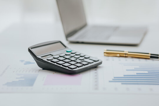 Selective focus office calculator with laptop and accessories on white background financial concept