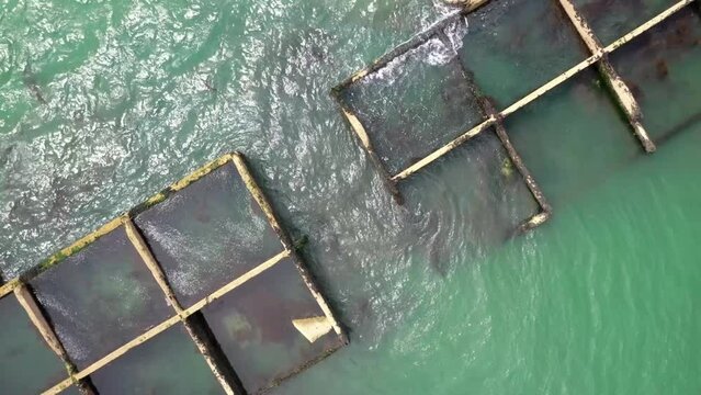 Arromanches en normandie, vestige d'un caisson phoenix sur la plage &agrave; mar&eacute;e haute, vue drone d'un reste du mulberry bridge  le port artificiel des troupes alli&eacute;es