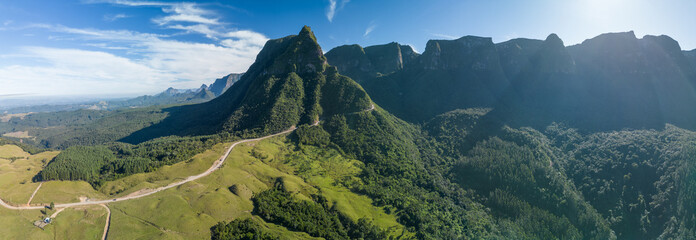 Panorama of the mountains in Brazil. Mountain range in the state of Santa Catarina, place named Serra do Corvo Branco with curved road leading up through the mountain pass - 619470146