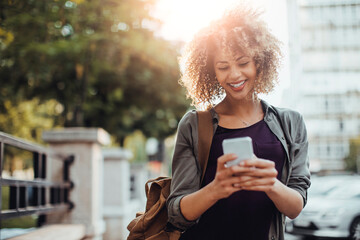 Young woman using a smart phone while on a city street