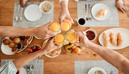 Lunch, hands and people toast with orange juice, beverage or glass drinks at lunch, brunch or food...