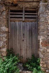 Fototapeta na wymiar Old wooden door in an abandoned traditional stone house in southern Peloponnese, Lakonia, Greece.