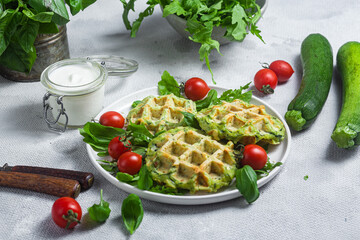 Zucchini waffles with arugula and cherry tomatoes in a plate