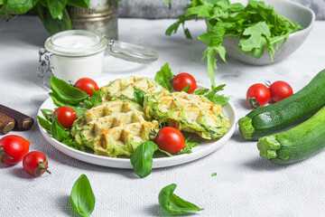 Zucchini waffles with arugula and cherry tomatoes in a plate