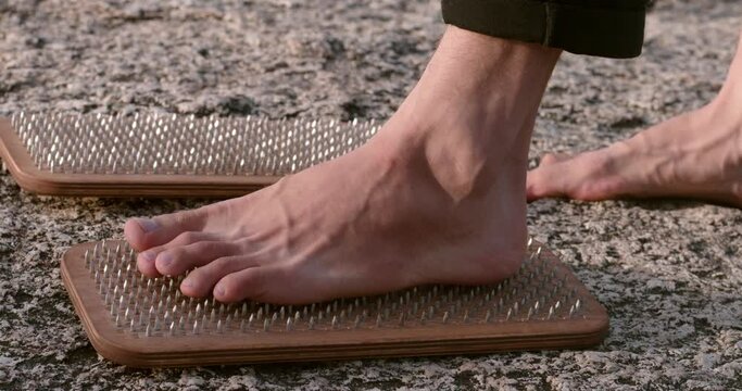 bare feet of yogi male preparing to stand on the sadhu boards with sharp body control strength practice body control male standing on nails meditation healthy body and mind body control concept