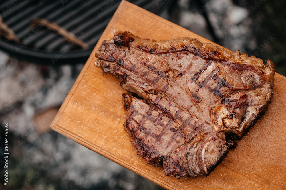 Wall mural Dry Aged Barbecue Porterhouse Steak T-bone beef steak sliced with large fillet piece with herbs and salt. American meat restaurant