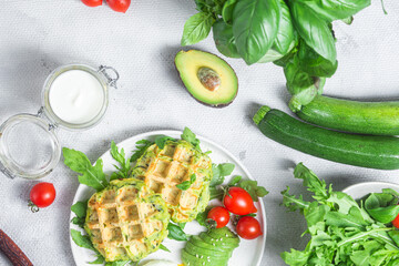 Zucchini waffles, poached egg, avocado and cherry tomatoes in a plate