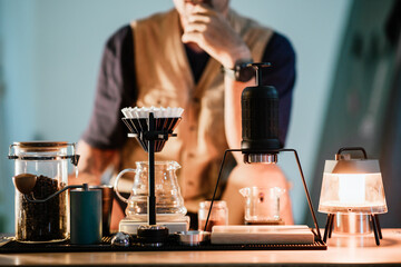 Barista making drip coffee with hot water being poured from a kettle, Ground coffee beans contained in a filter, Make drip coffee, Slow bar coffee.
