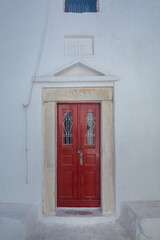 Red door in an old white church in Mykonos, Cyclades, Greece.