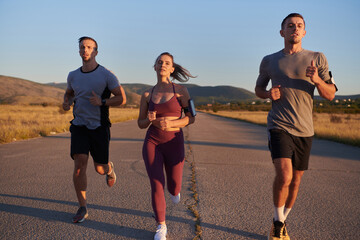 A group of young athletes running together in the early morning light of the sunrise, showcasing their collective energy, determination, and unity 