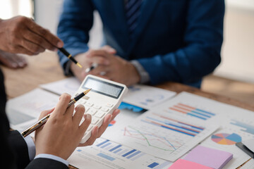 Businessman is reviewing monthly sales documents for analysis and marketing plans for more sales growth, they are the founders of young companies co-founding startups. Sales management concept.