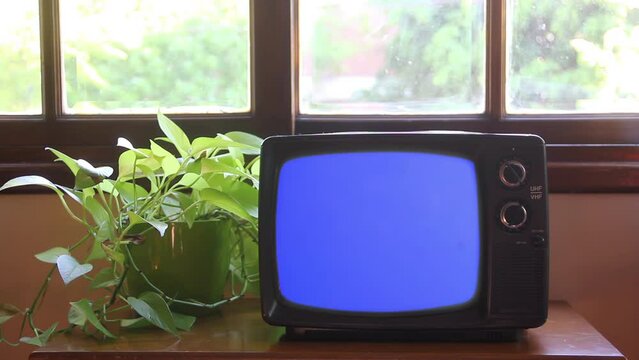 Old Television Turning On Blue Screen Against a Window in a House - Close Up - 4K