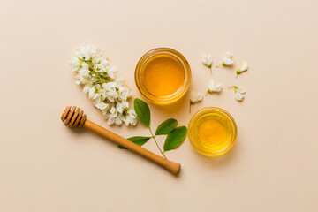 Obraz na płótnie Canvas honey jar with acacia flowers and leaves. fresh honey top view flat lay