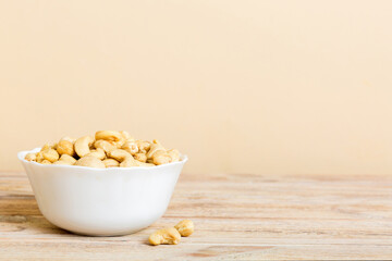 cashew nuts in wooden bowl on table background. top view. Space for text Healthy food